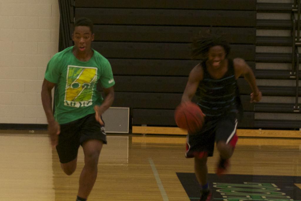 Varsity basketball players juniors Henry Logan and Deione Carter run the court during preseason workouts Sept. 25. The boys basketball team has been conditioning to prepare for the season. I just love the competitiveness and the intensity, said Logan.