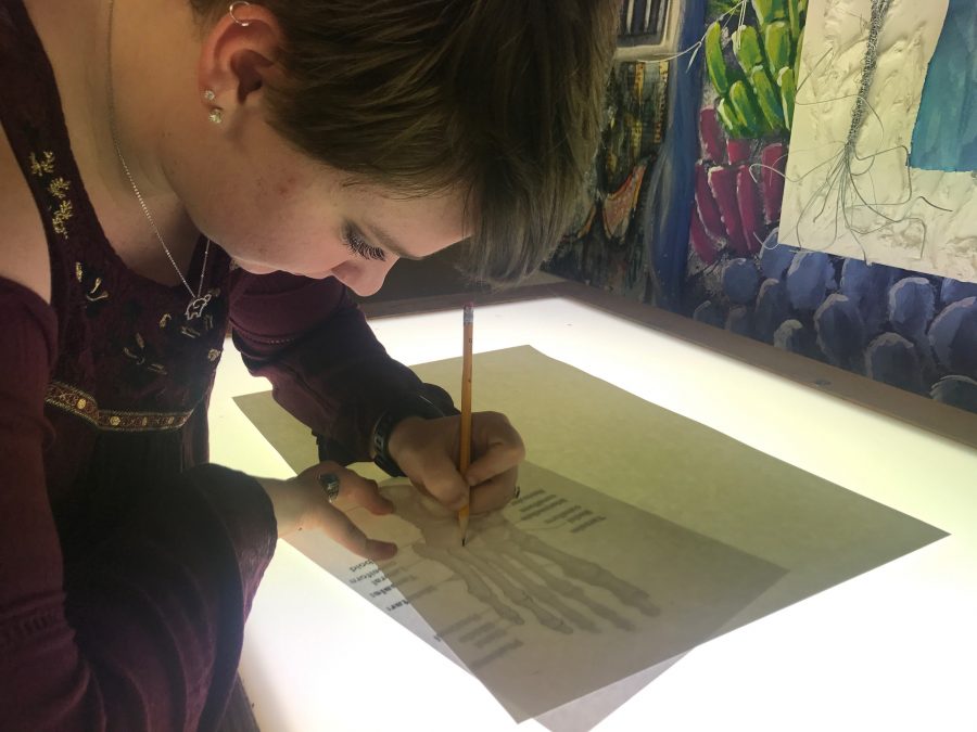 Using the light board in AP Studio art, senior Maddie Mummert is working on one of her concentrations for her portfolio on Feb. 21. The students in AP Studio Art have 20 more blocks before submitting all projects. “My favorite thing about art is being able to come into a classroom and leave all worries at the door and let yourself go in the work you’re doing,” said Mummert. 
