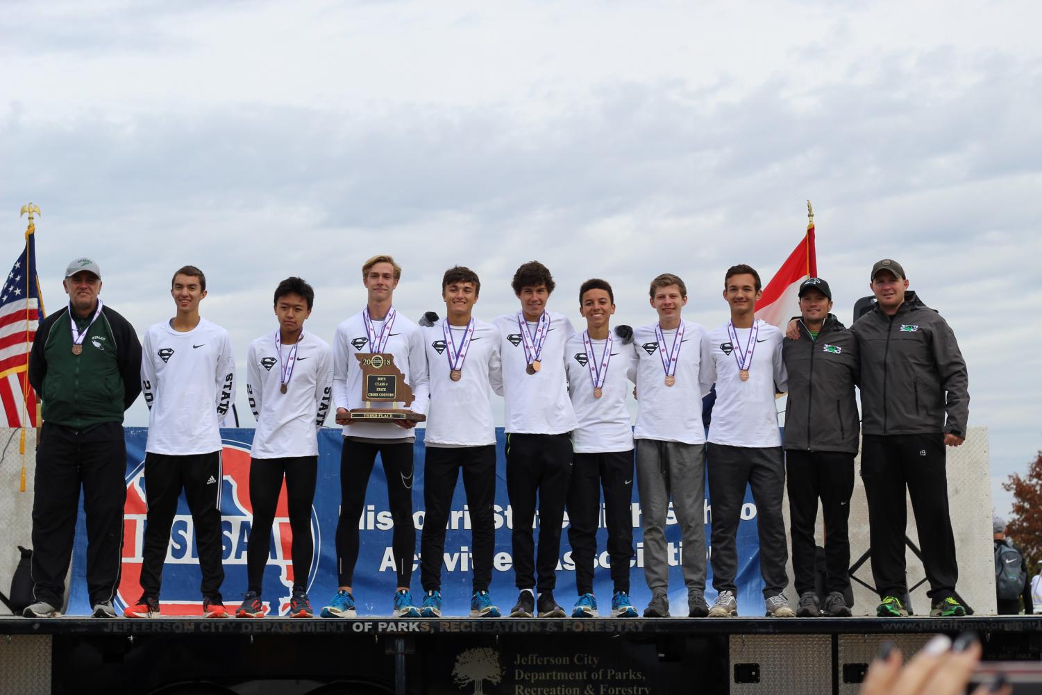After winning third place as a team at cross country state Nov. 3, runners juniors Murphy Corum, Nathan Nguyen, senior Preston Wheeler, juniors Luke Winkler, Jack Warner, Collin Riggins, sophomores Dawson Walker and Drew Sallman stand while wearing their new medals. This was the first time since 1983 that a North Kansas City School District school made it to the podium at state.