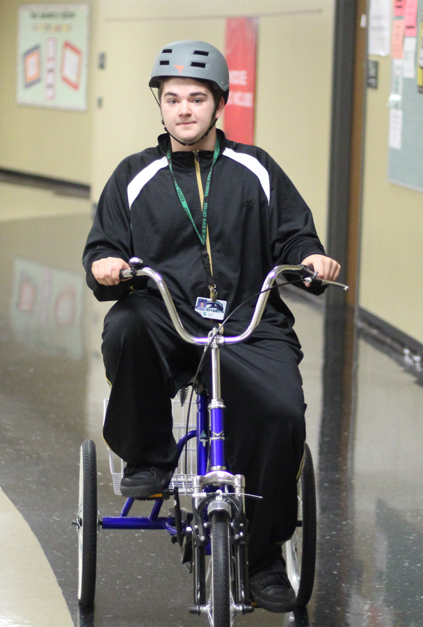 In the hallway on May 2, senior Josh Roush rides the new tricycle. It was not the senior’s first time on a tricycle. “[Roush] just nailed it,” said to Rohlfing. 