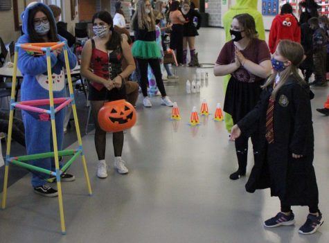 Senior Dory Gonzalez, junior Abi Reyes and senior Allison Sampel cheer on a guest as she plays their bean bag toss.