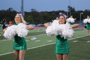 Performing with the Emeralds at the Homecoming game against North Kansas City High School Sept. 24, senior Sofia Cascone and junior Isabella Cascone shake their pom-poms. The Cascones have danced as a duo for 15 years, but their time will be coming to a close as Sofia graduates. “I’m going to be really sad,” Isabella said. “It’s something we’ve been able to do together and share a passion together.