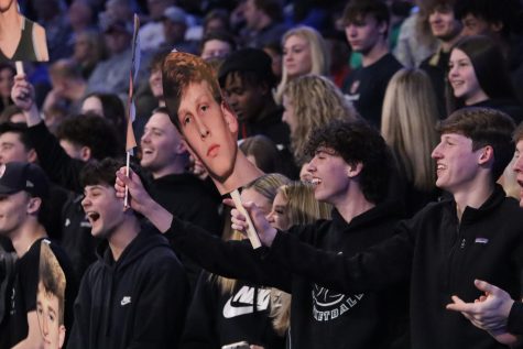 During the quarterfinal game March 5, seniors Alex Gonzalez, Drew Atkins and Jackson Scott cheer for the basketball team as Scott and Atkins hold up a Fathead of senior Brogan Donaldson. The Fatheads were designed by student section leader Tommy Martin’s mom. “She knows them, and she’s always kind of known them, so she created those signs as a joke,” Scott said.