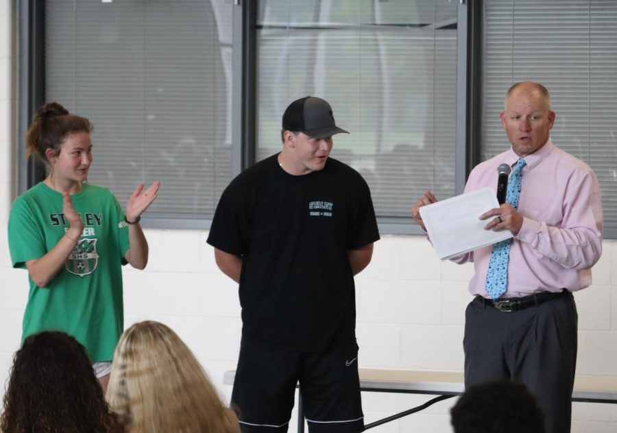 Sophomore Katy Taylor claps as her dad, coach Shane Taylor addresses his athletes at the Track and Field banquet May 10.