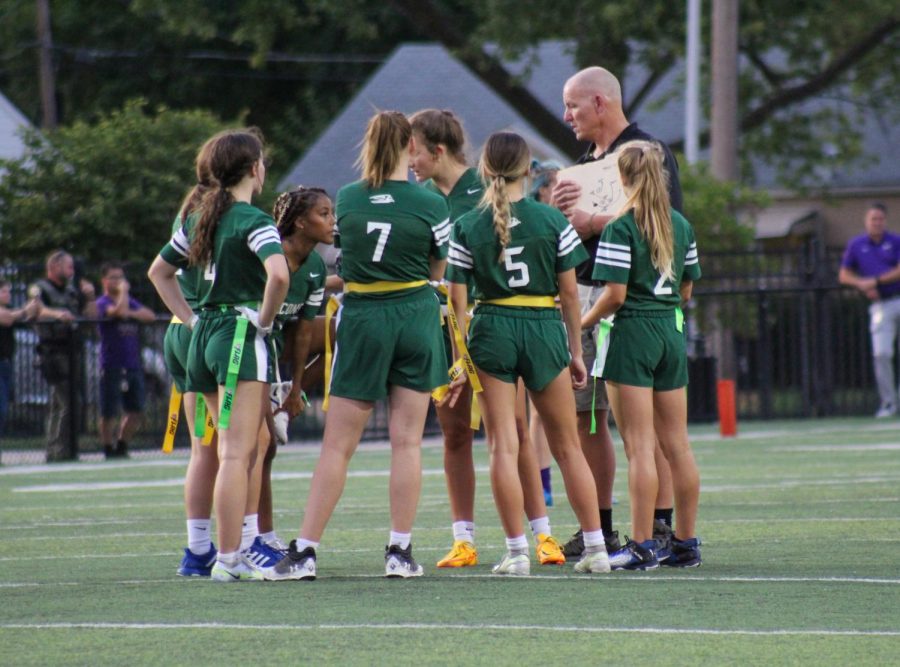 During the flag football game against North Kansas City High School Sep. 2, the team huddles in discussion. The flag football team lost 6-13. “It was really nice, just playing with them and getting to know them to the level that we did," Katy Taylor said.