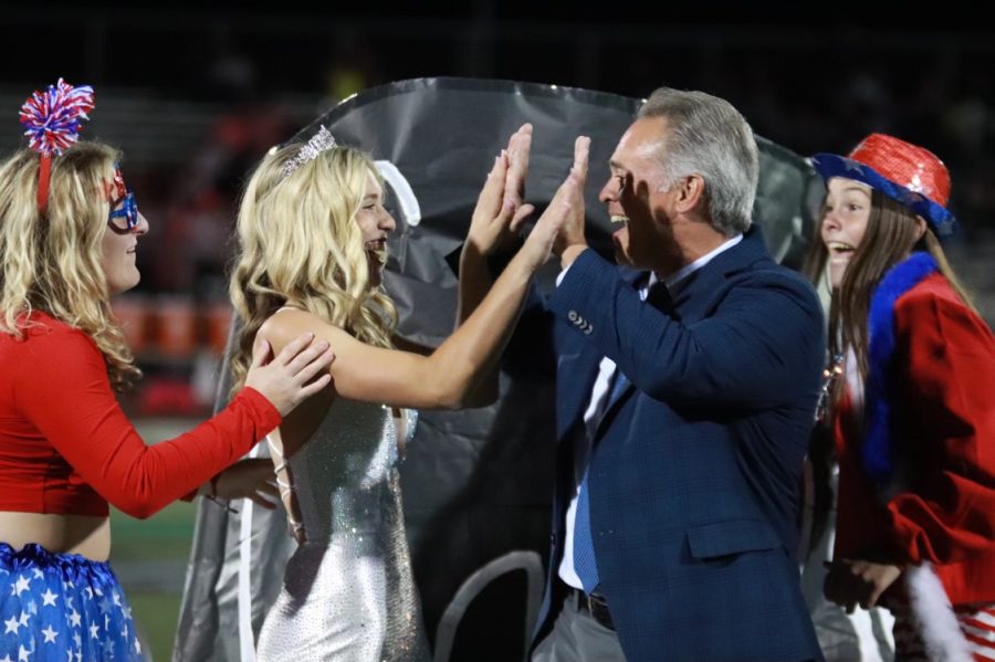 After being announced as 2022 Homecoming Queen, senior Caroline Ray high fives her father.