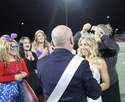English teacher McKay Lannigan pins Rays crown as other candidates and their banner holders cheer. 