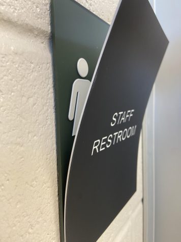 A staff restroom placard covers what used to be a picture indicating it was a gender neutral bathroom.
