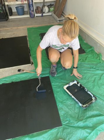 For her Girl Scout Gold Award, junior Avery McKenna paints sensory boards for the playground at Newhouse K.C. 