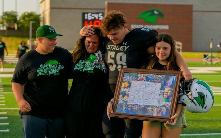 During senior night at the home varsity football game Aug. 26 at the District Activities Center, senior defensive lineman Tyler Shanks comforts his family as they celebrate his last year and mourn the loss of his father. Shanks’ father passed away during his freshman year, and that has been one of his major motivators as an athlete since.