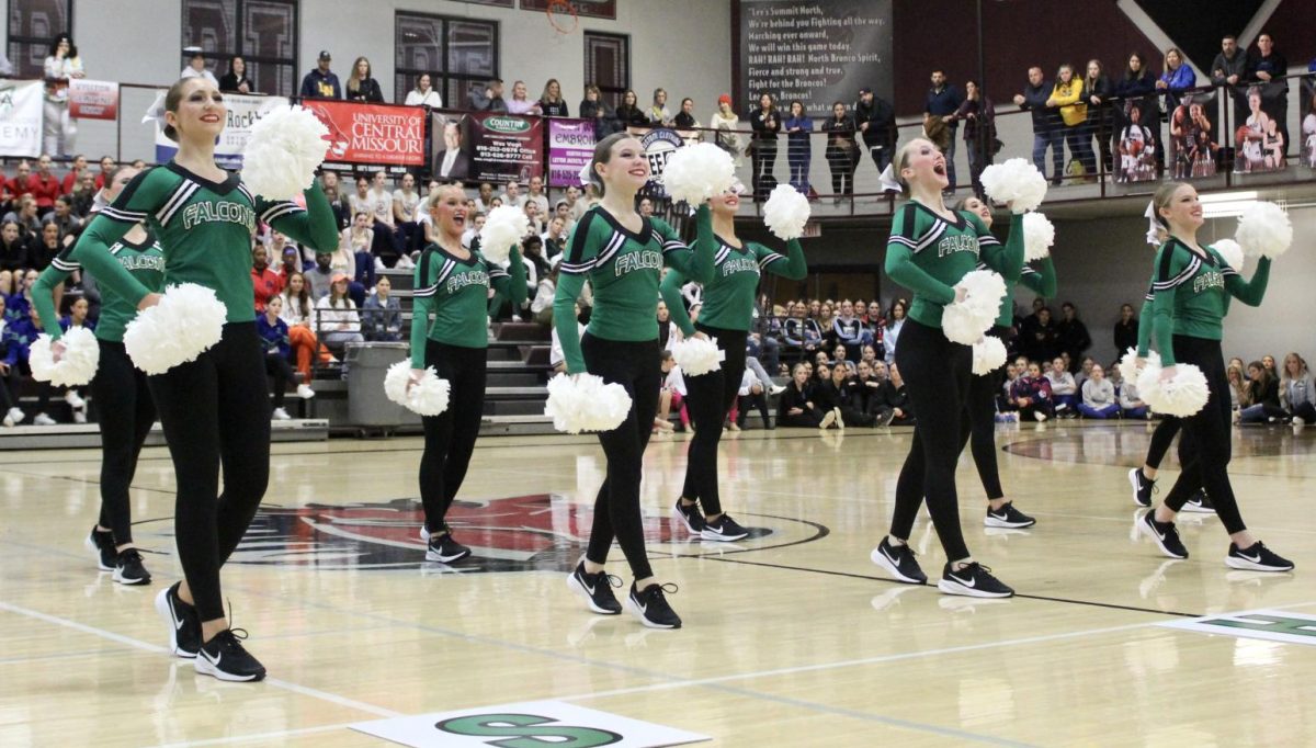 While stepping into dance, sophomore Lyla Reeves, junior Sarah Tarpley, Kenzie Cornett and Carlie Redd lift up their poms as they perform their routine on Jan. 20 at Lees Summit North Invitational. The team scored third in Precision Jazz, sixth in Pom and fifthin Game Day. All six soloists medaled in their division. The season has been going pretty well, Tarpley said. Its not the best for what we want right now, but we have high hopes for state and nationals.