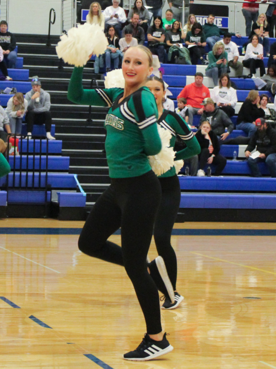 As she holds her pom up, junior Kenzie Cornett performs for the KC Classic competition on Dec. 9 at Liberty High School. I think competition season is going well. Weve had lots pf fun as we get to showcase what weve been working on.
