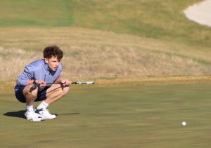 At practice March 5, junior Charles Moburg eyes the ball. The team prepared for the season by practicing at Staley Farms Golf Course. 