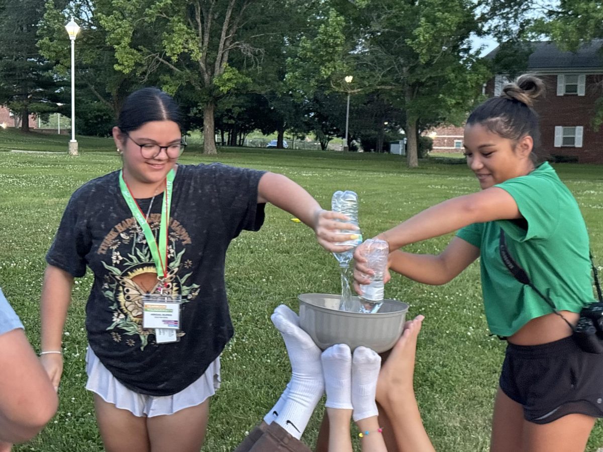 Pictured above Senior Abbeygail burres (left)  and Ava Holmes (not pictured) were compearing in the “Jostens Youniversity” Olympics. The event was water bowl. The goal try not to spill the water as you remove a foot from the bowl. Ava Holmes was one of the ones who was balancing the bowl the hardest part “Honestly, when we took one of our feet away. It was hard balancing because it was half the amount of feet and everyone was trying to balance it without their hands”